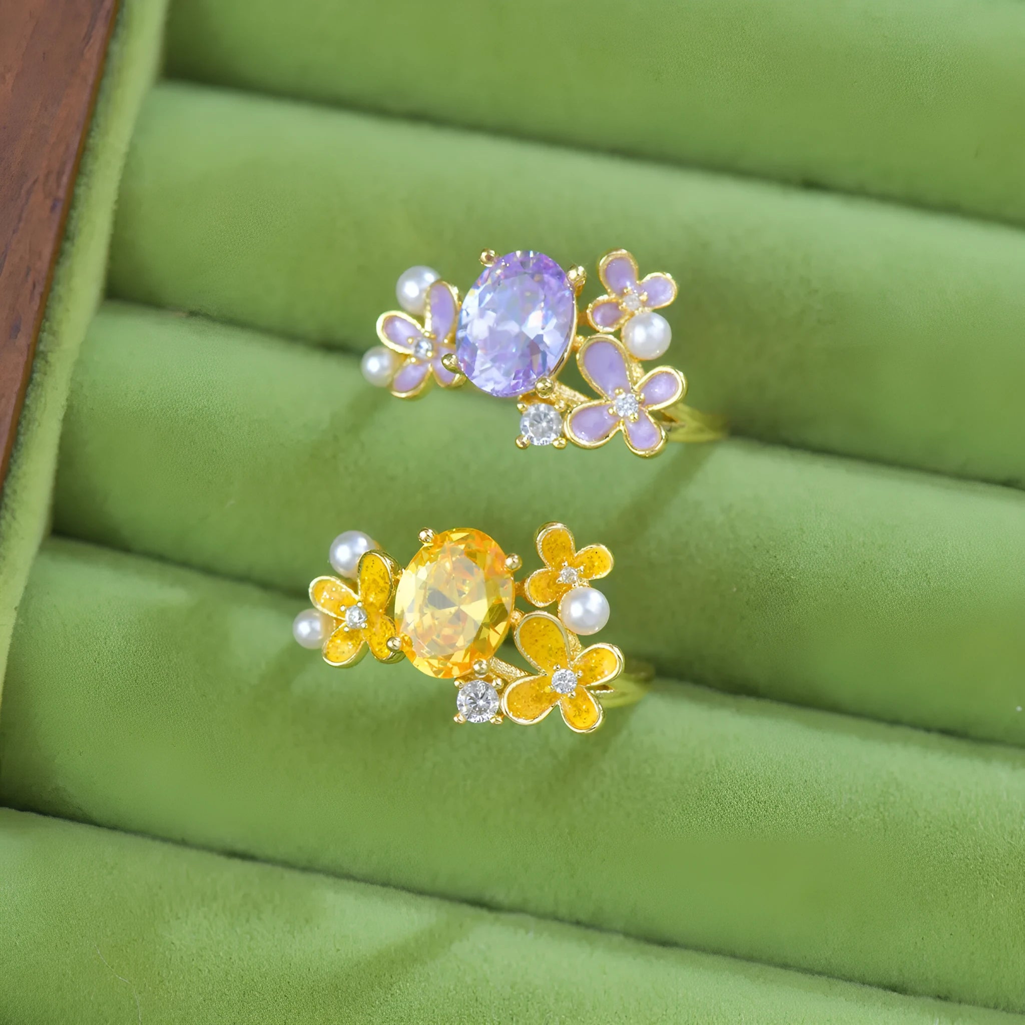 Yellow women's open ring with a flower shape and zircon detailing on a white background.