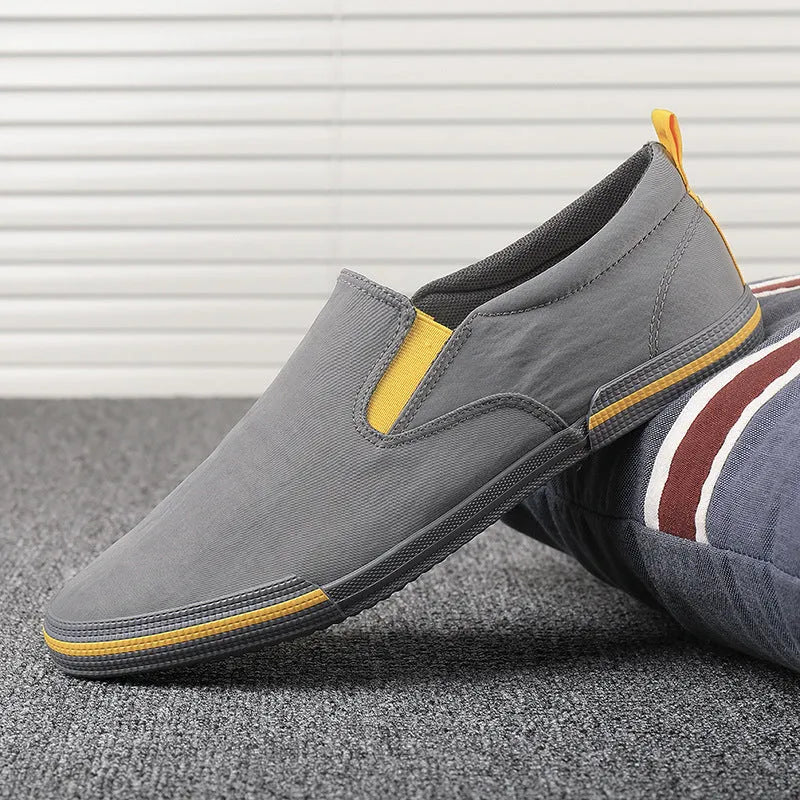 Men's low-top canvas casual shoe in grey with a vulcanised rubber sole and rounded toe.