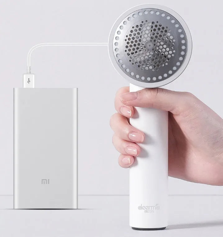 White rechargeable lint remover with hidden hair collection container and detachable three-blade head on white background