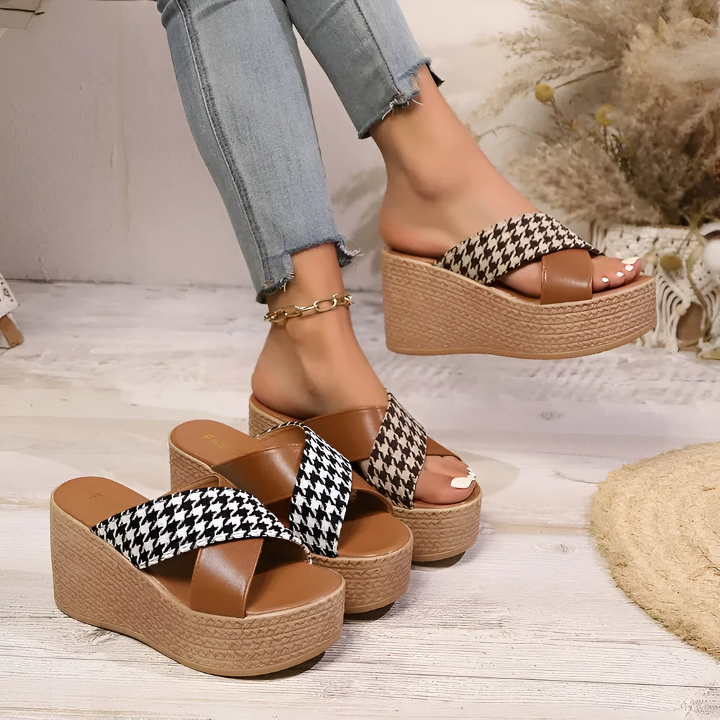 Brown and black plaid pattern wedge sandals with a rubber sole on a white background.