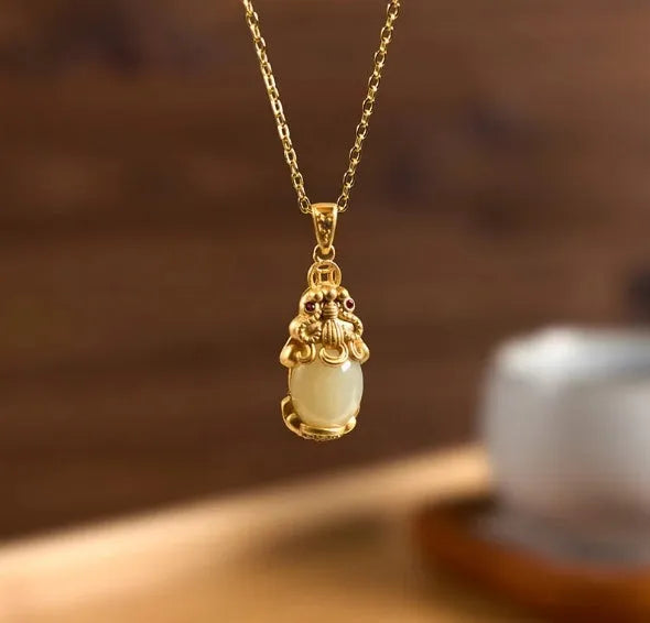 Cartoon character Hetian white jade antique gold pendant necklace with emerald pixiu charm on a chain.