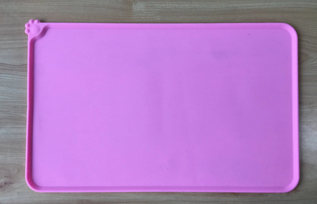 Black silicone dog food mat measuring 47 by 30 centimetres with non-slip surface and raised edges.