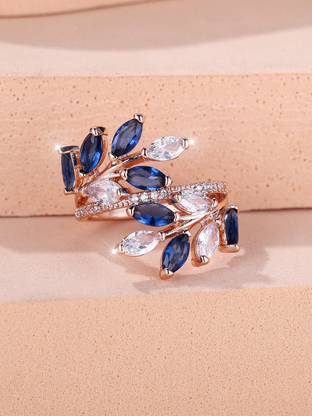 Adjustable copper leaf ring with a horse eye zircon stone in multiple colour finishes on a neutral background.