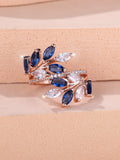 Adjustable copper leaf ring with a horse eye zircon stone in multiple colour finishes on a neutral background.