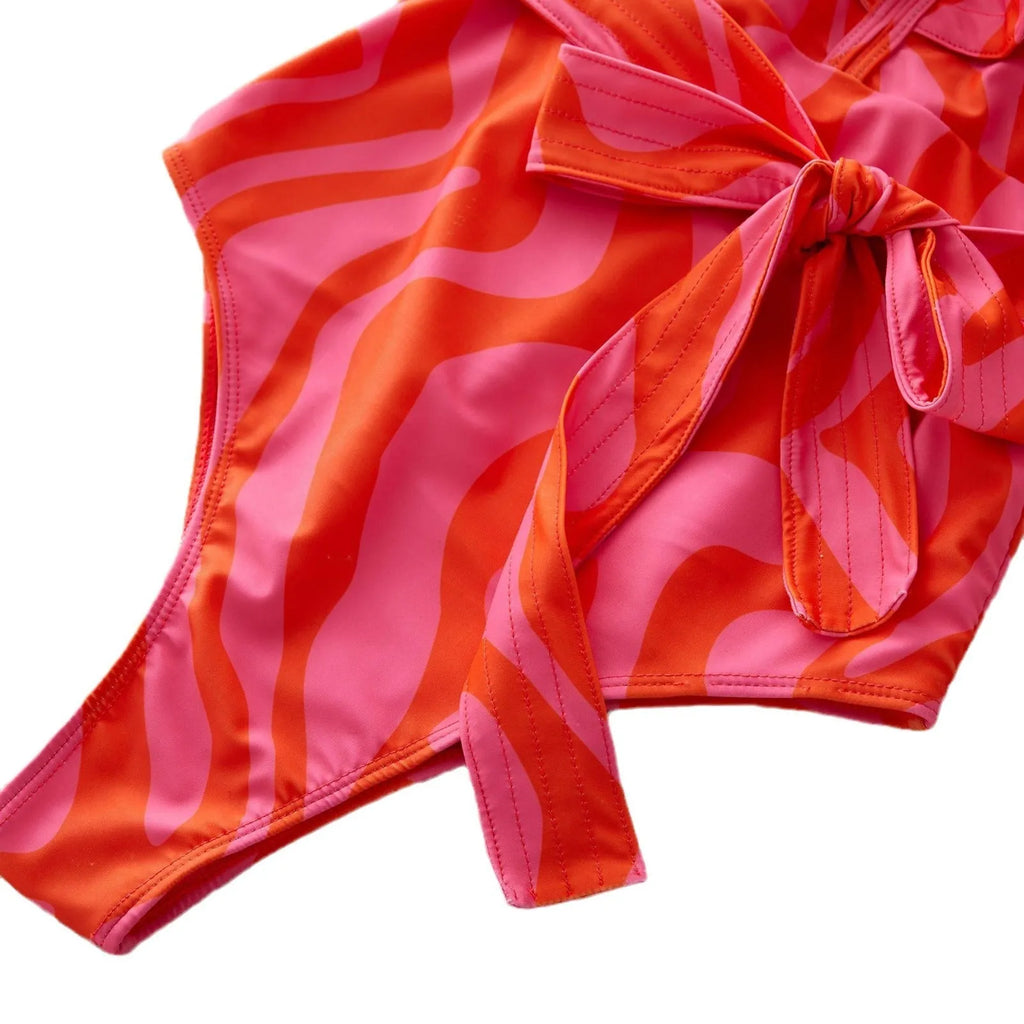 Women's one-piece swimsuit with double-shoulder ruffles, deep V-neck mesh stitching, and printed pattern.