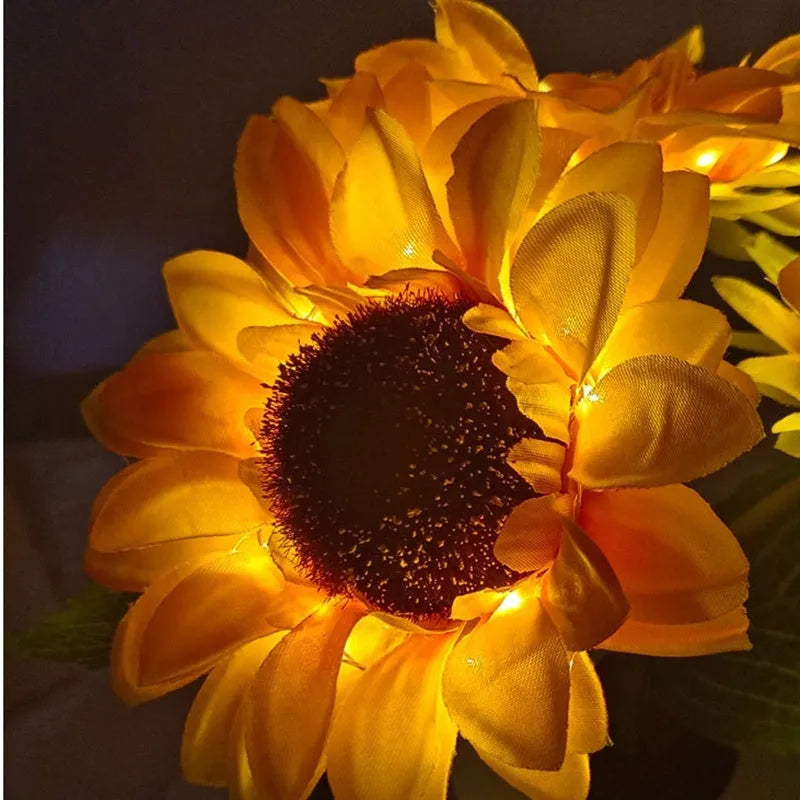 Rechargeable artificial sunflower LED night light on a table with USB charging cable.