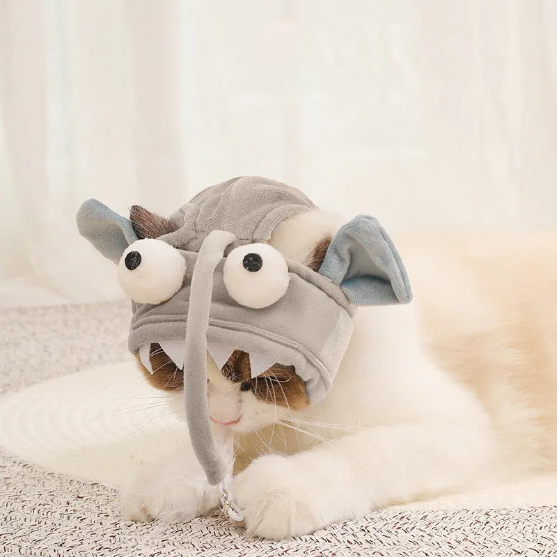 Grey head-mounted cat toy with feather and big-eye fish attachments on adjustable elastic band
