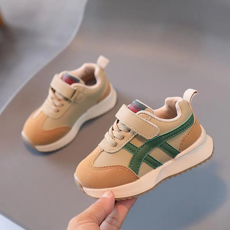 Children's white synthetic leather sneakers with Velcro fastening and textured rubber sole.