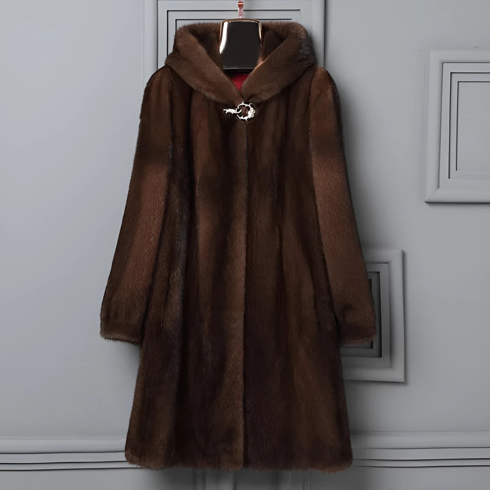 A woman's long black faux fur coat with a hood, shown in a street fashion style.