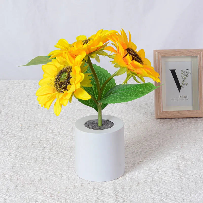Rechargeable artificial sunflower LED night light on a table with USB charging cable.