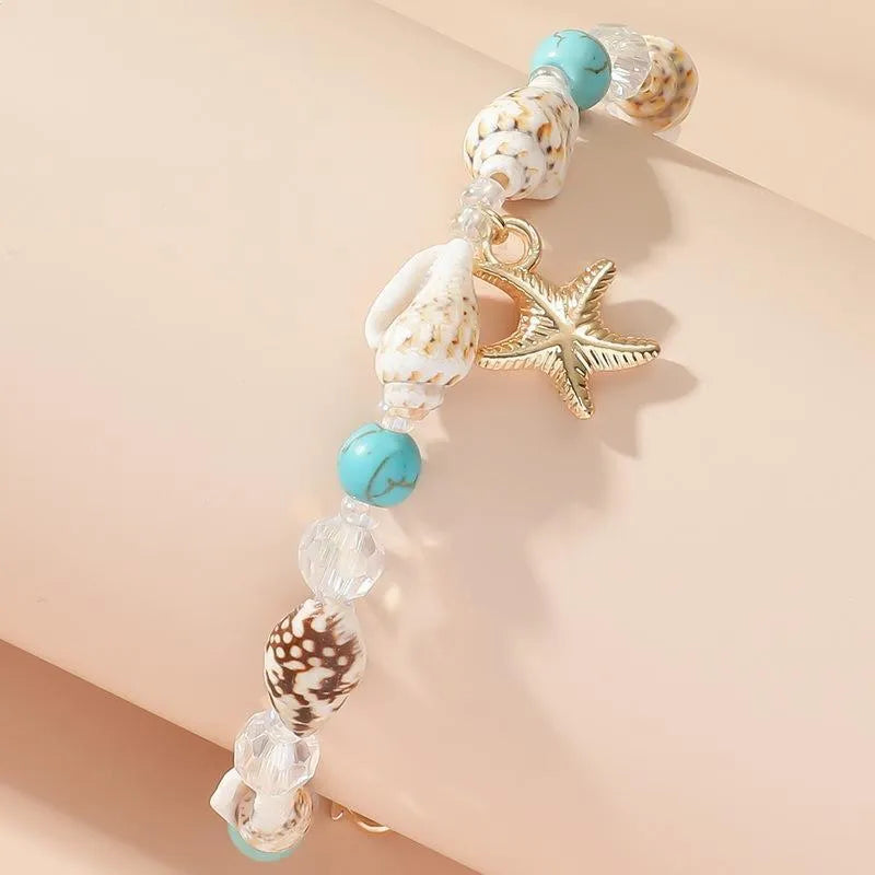 Alloy shell crystal beads bracelet with starfish pendant and conch beads on white background