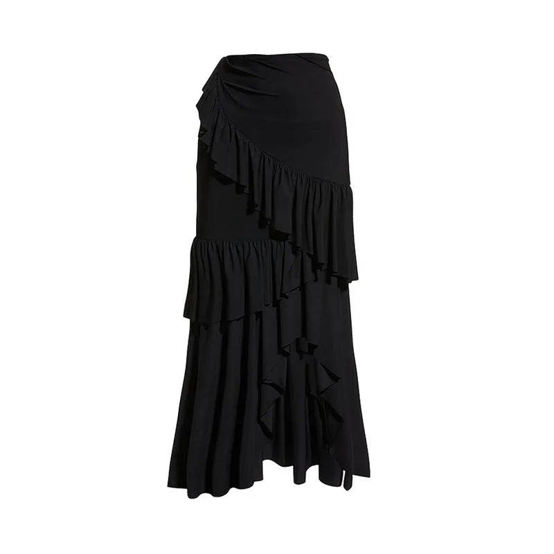 Women's black and white one-piece swimsuit with a detachable skirt laid flat on a beach towel.