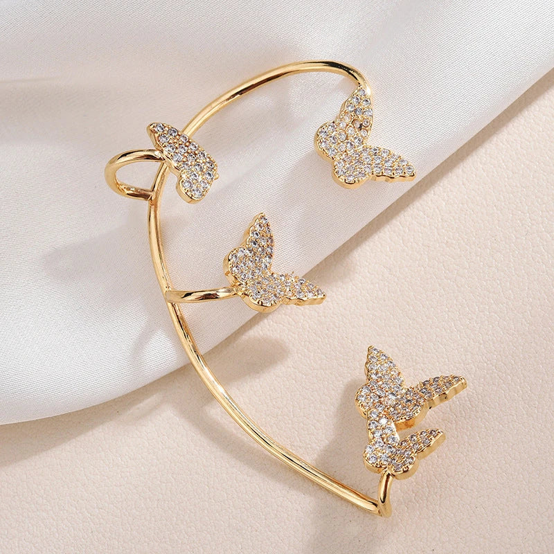 Sparkling zircon butterfly ear cuffs in gold-toned metal, featuring a delicate and elegant design for stylish accessorizing