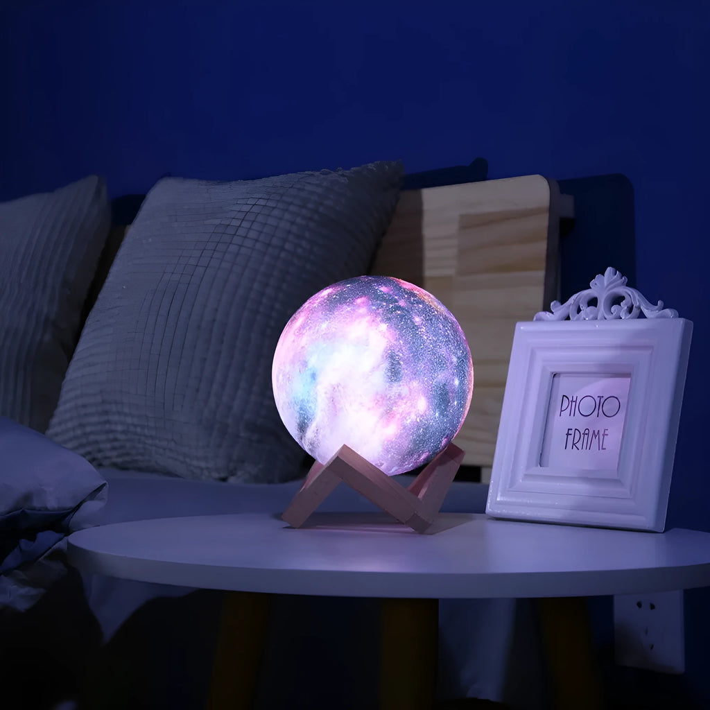 3D-printed spherical lunar night light with remote control on a dark surface.