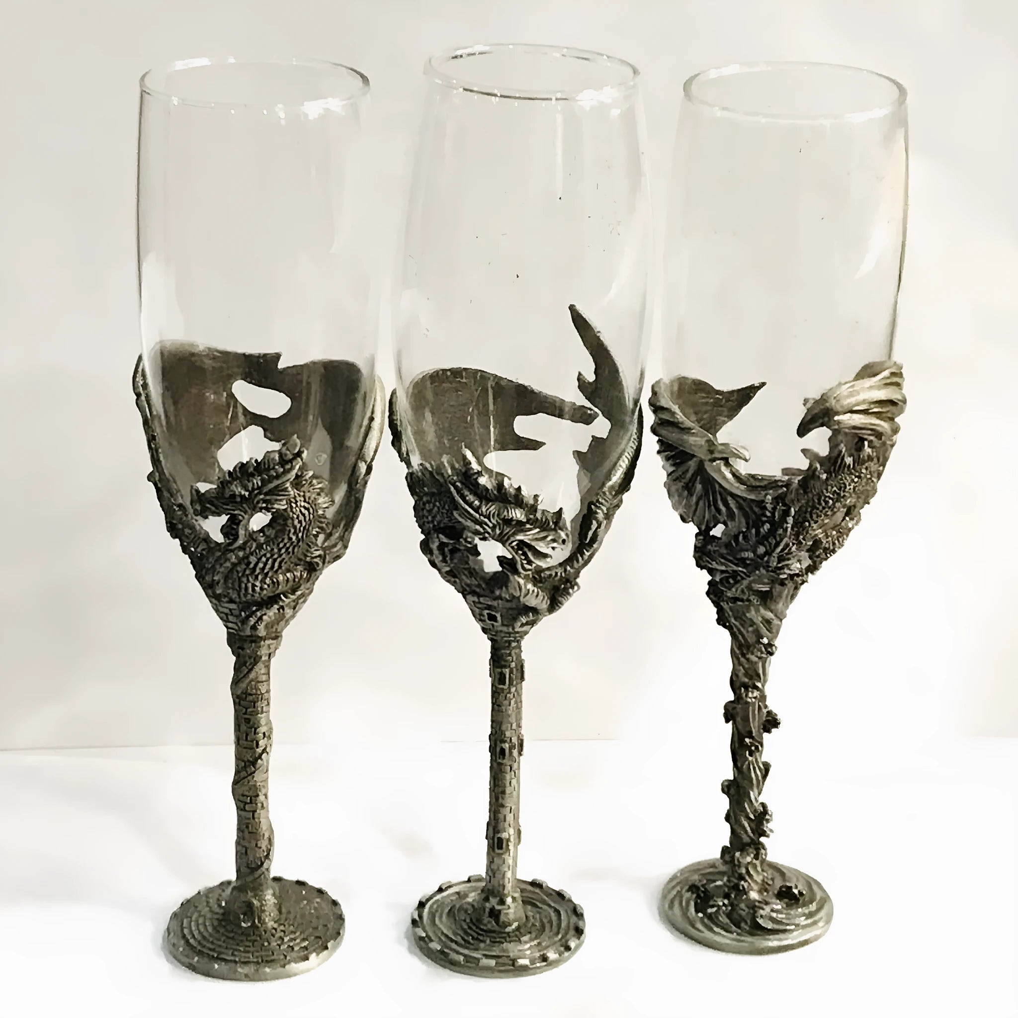Alloy dinosaur champagne glass goblet in ancient tin colour on a surface, 21cm tall, retro style