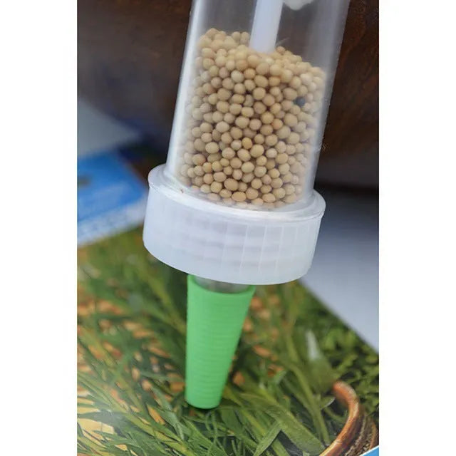 Green plastic mini garden seeder tool with adjustable thumb button, 12cm length