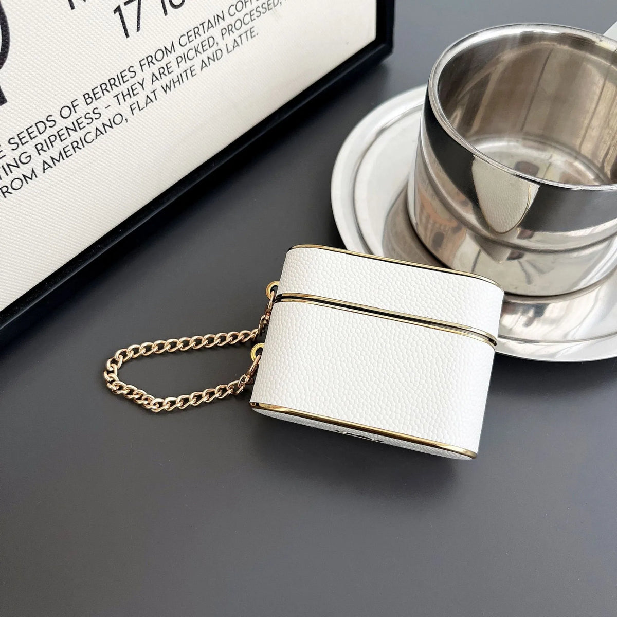 TPU protective cover for AirPods in black with frosted finish and chain attachment.