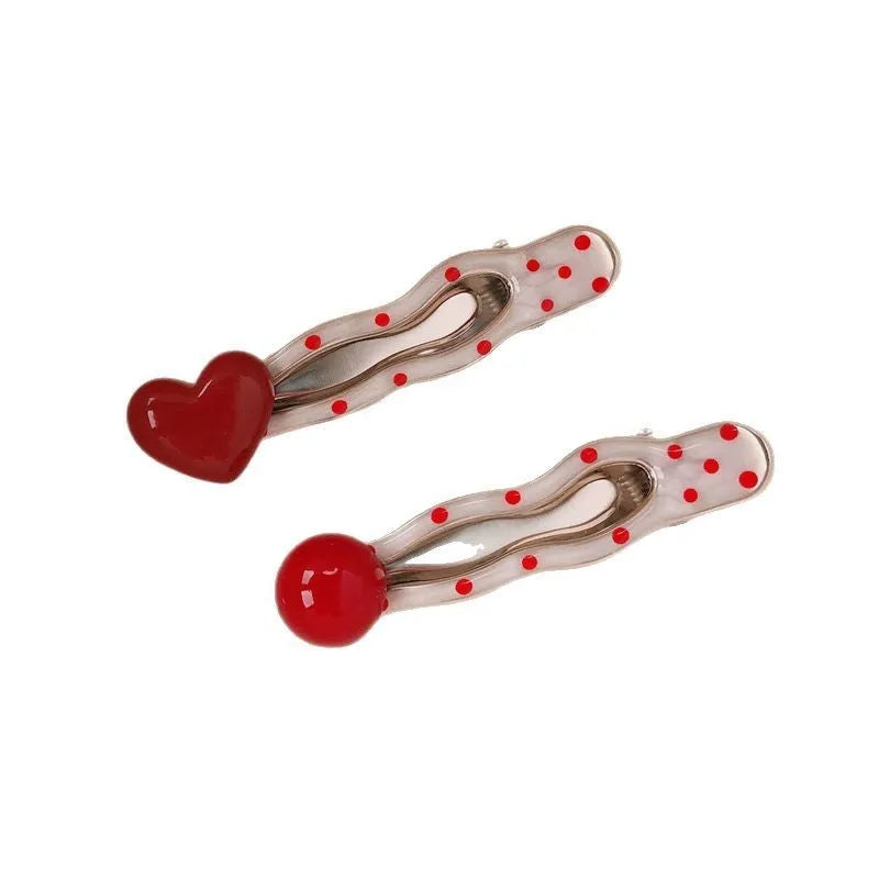 Red love heart shaped hair clip with dotted patterns and willow leaf designs on a barrette