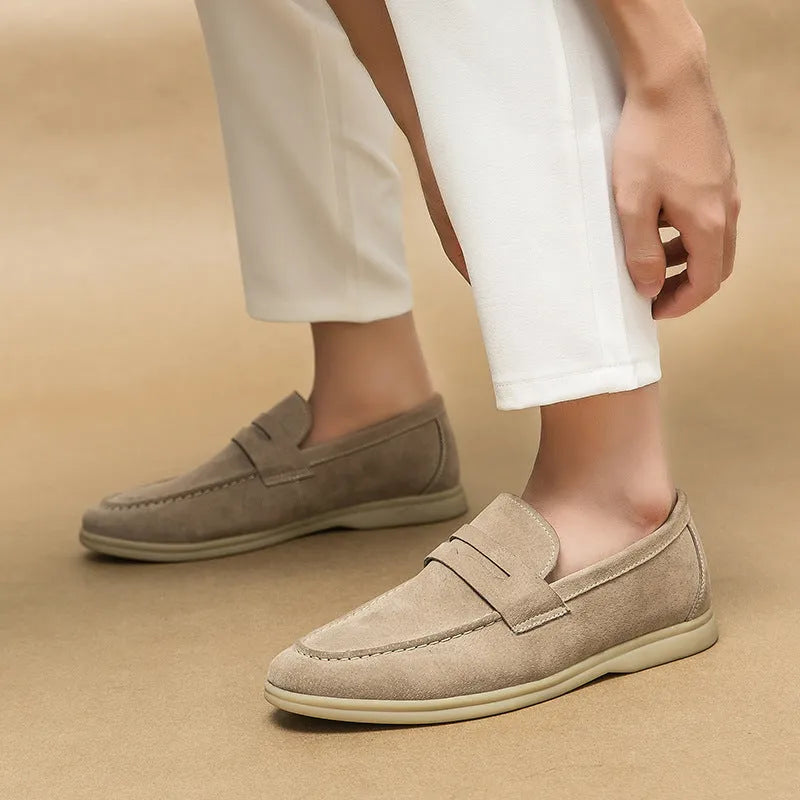 Men's beige leather slip-on shoes with a round toe and mid heel on a rubber sole.