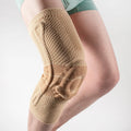 Adult sports knee pad in black and blue colour, made from nylon and spandex, shown on a knee.
