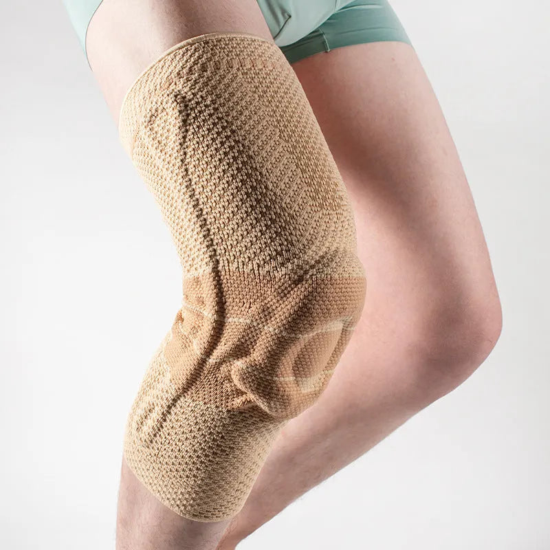 Adult sports knee pad in black and blue colour, made from nylon and spandex, shown on a knee.
