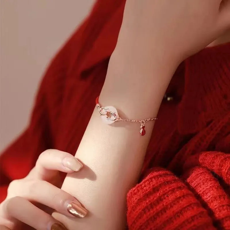 Festive koi bracelet with peace buckle fastening, adjustable red rope and fish tail decorative elements