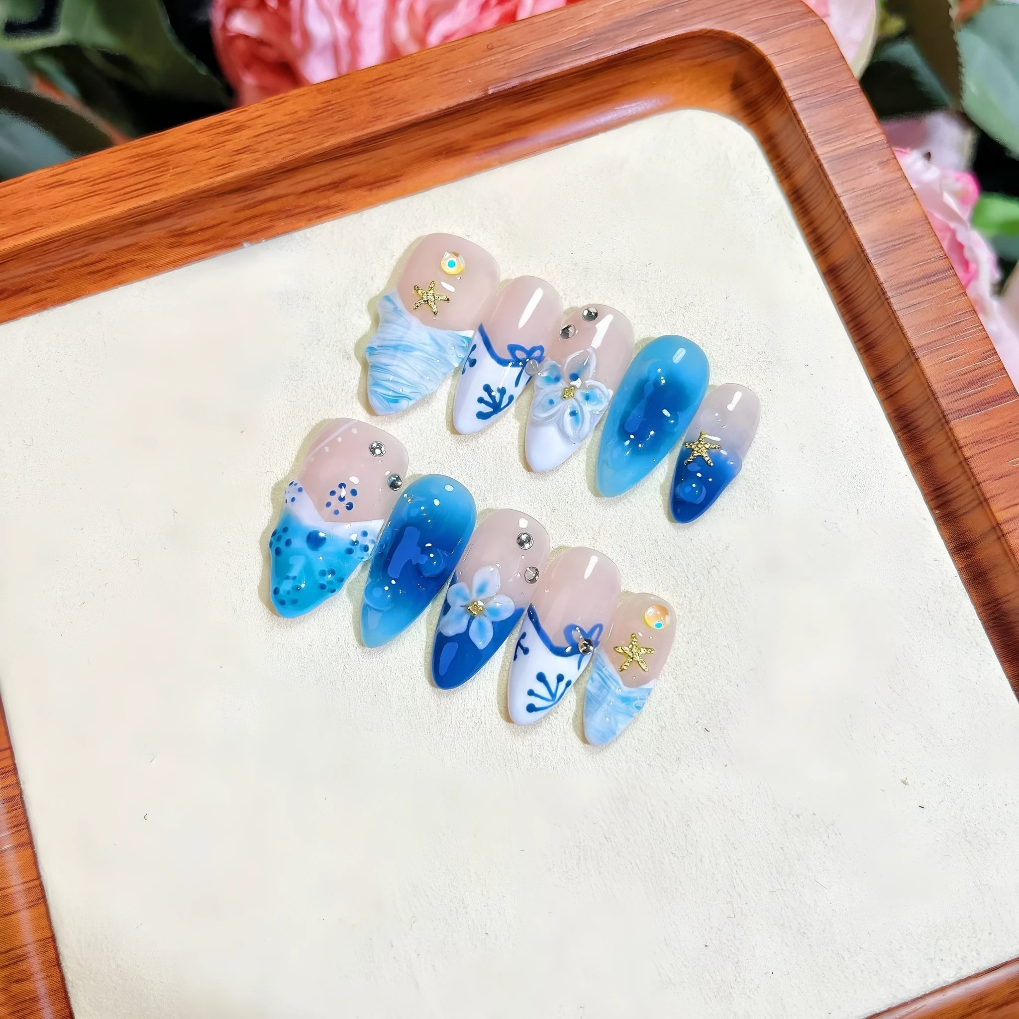 Blue carved designs on transparent fake nails showing summer ice aesthetic