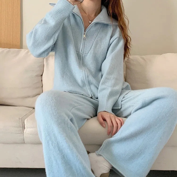 Woman wearing a knitted zipper cardigan and wide-leg trousers from a solid colour two-piece set.