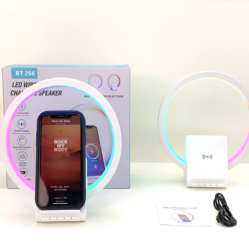 White smart Bluetooth speaker with integrated wireless charging pad and ambience light on a desk.