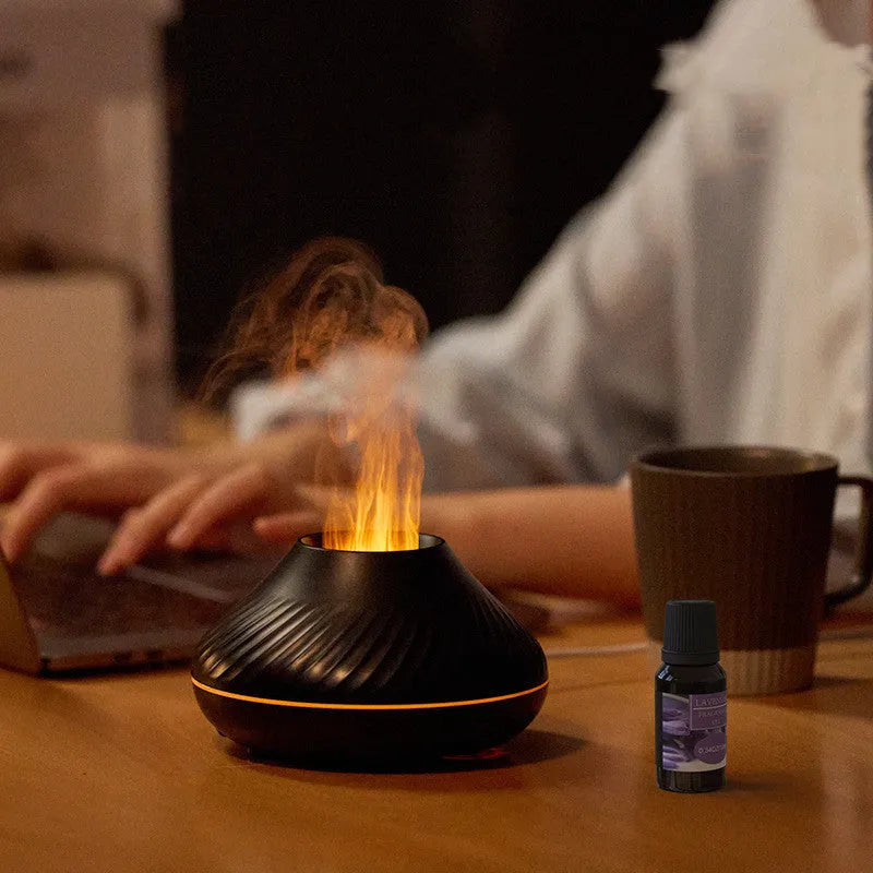Beige USB aroma diffuser with flame-effect mist and colour-changing night light on a wooden table.
