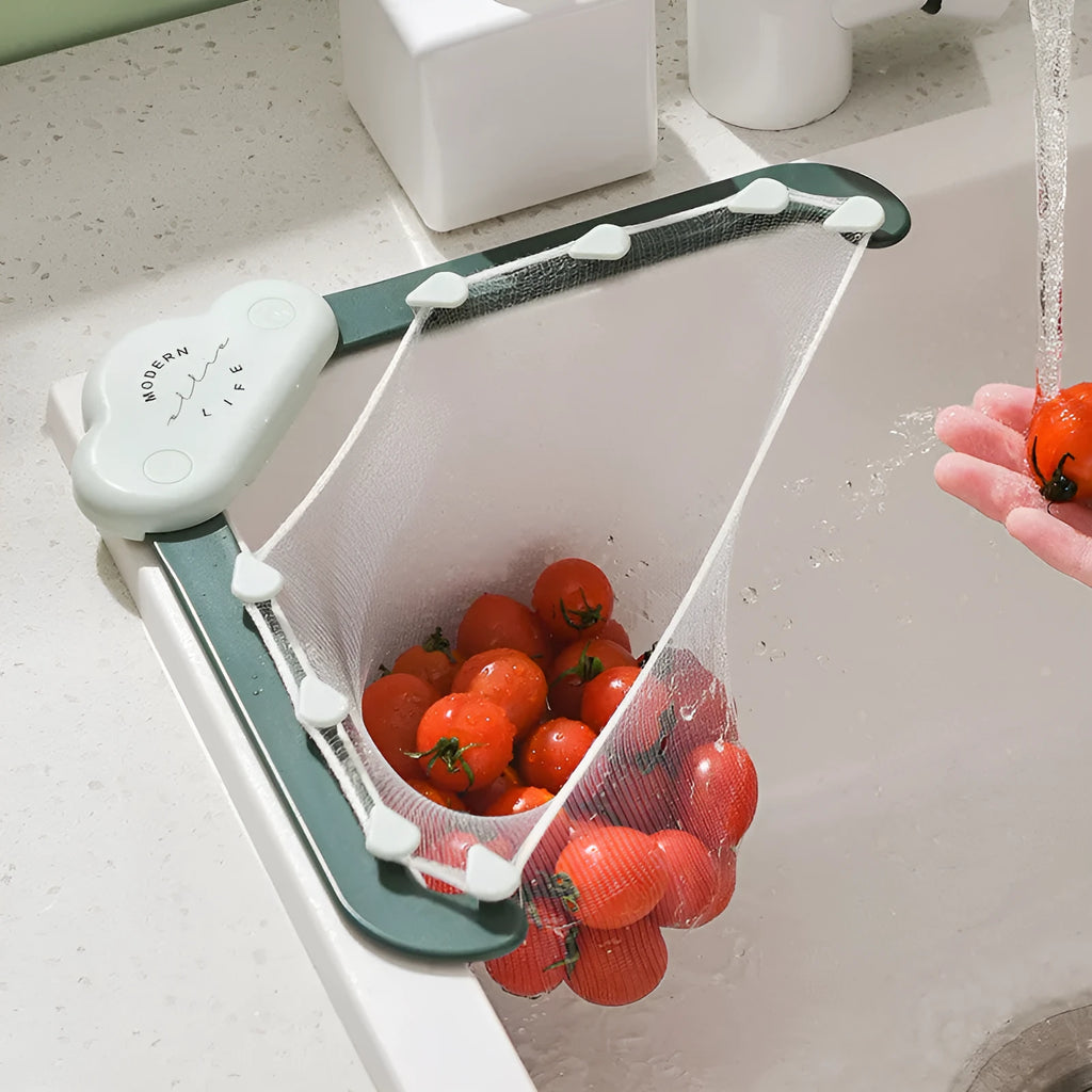 Green triangular ABS plastic sink drain rack with elastic mesh filter net installed in kitchen sink corner.