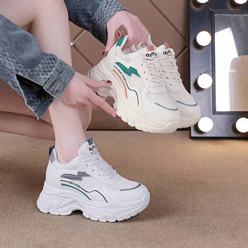 Women's white breathable dad shoes with height increasing insole and lace-up front.