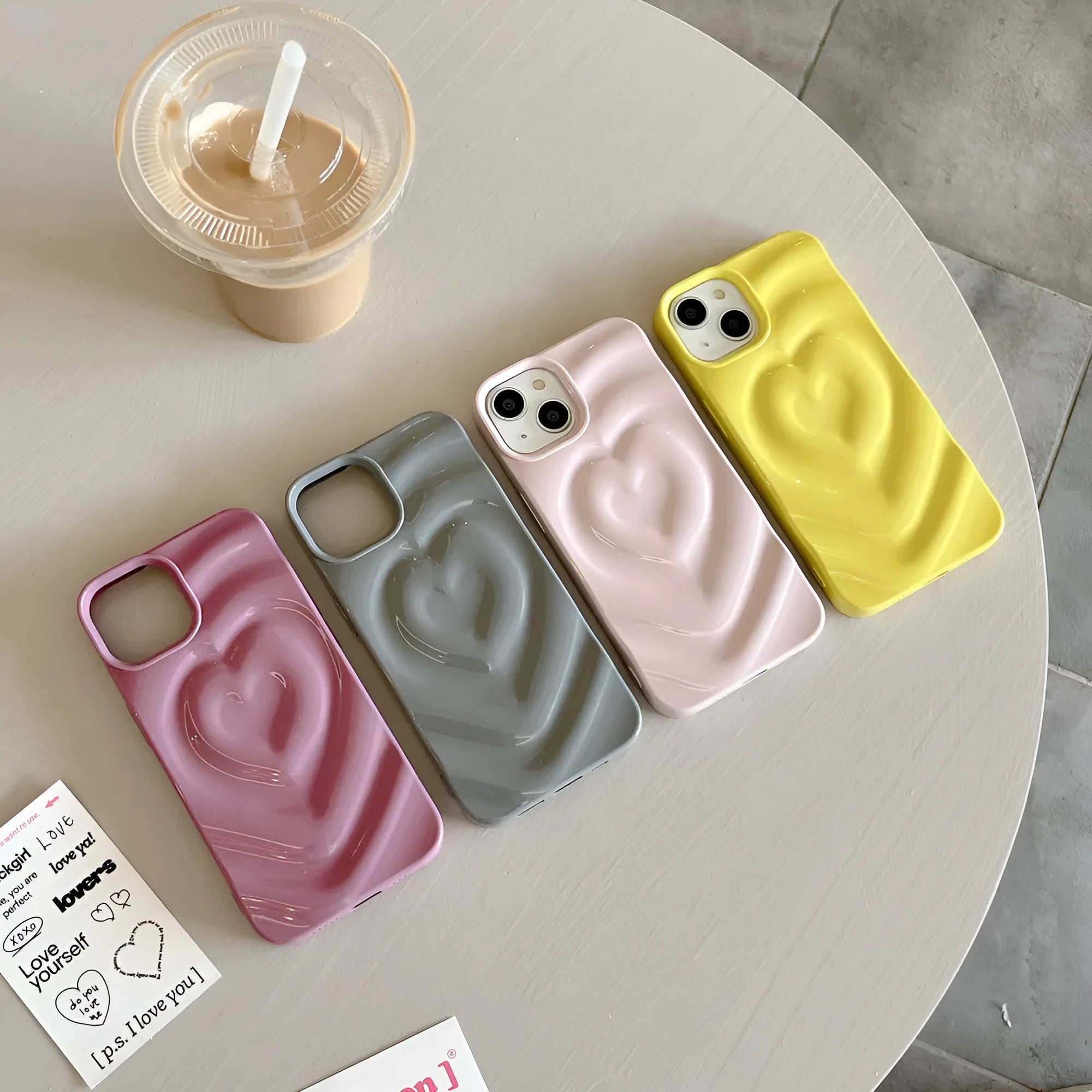 Solid colour iPhone case with a raised 3D love design on the back, shown in bright purple.
