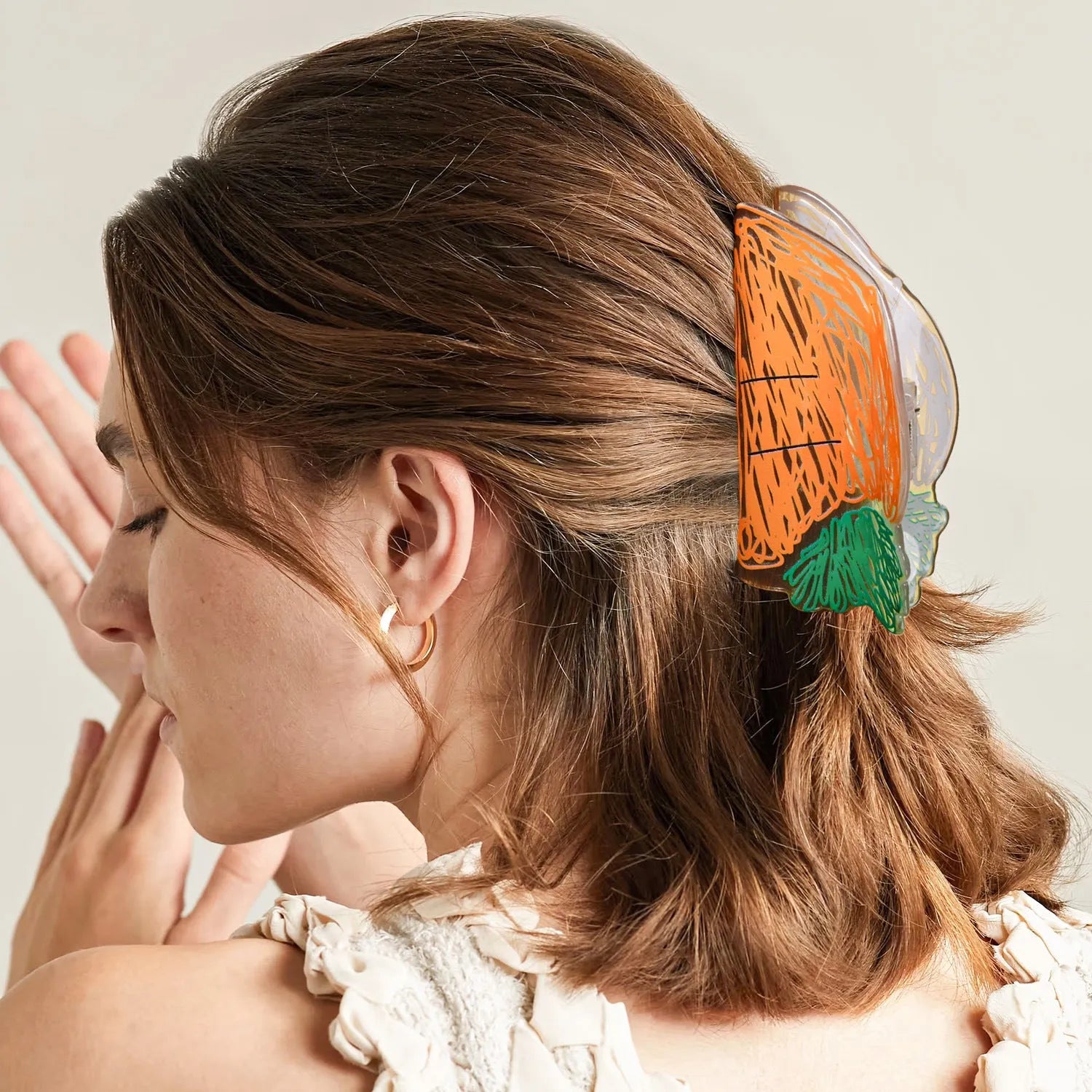 Korean creative fruit transparent PVC hair grip with asymmetric design on a white background
