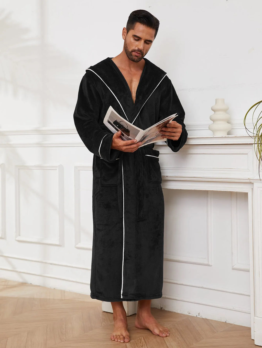 Man wearing a light grey flannel-style bathrobe at home, showing the front wrap design and soft texture.