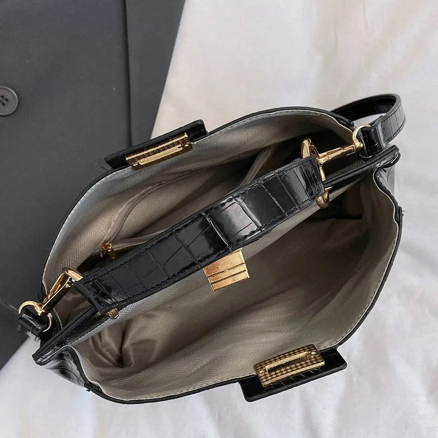 Retro western style messenger bag in black stone pattern with shoulder strap and square vertical shape