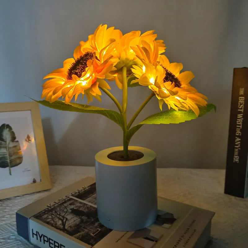 Rechargeable artificial sunflower LED night light on a table with USB charging cable.