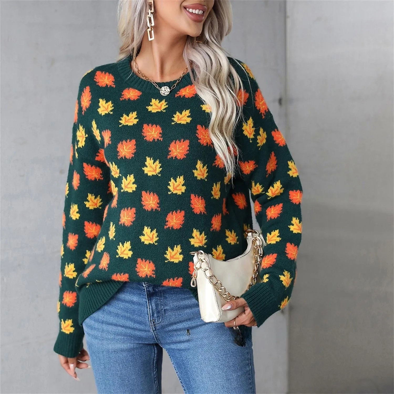 Loose fit beige Christmas sweater with a large dark maple leaf print on the front.