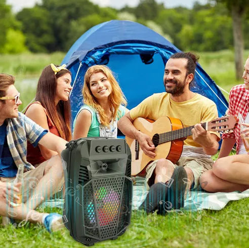Black portable Bluetooth speaker with microphone and subwoofer on outdoor setting