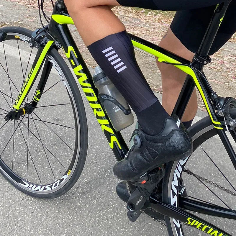 A pair of breathable cycling and running socks in an orange colour on a plain background.