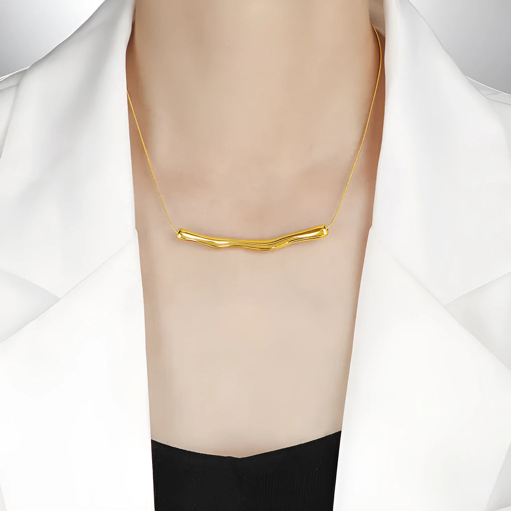 Close-up of a women's titanium steel necklace with an irregular pleated pendant in a gold-tone finish.