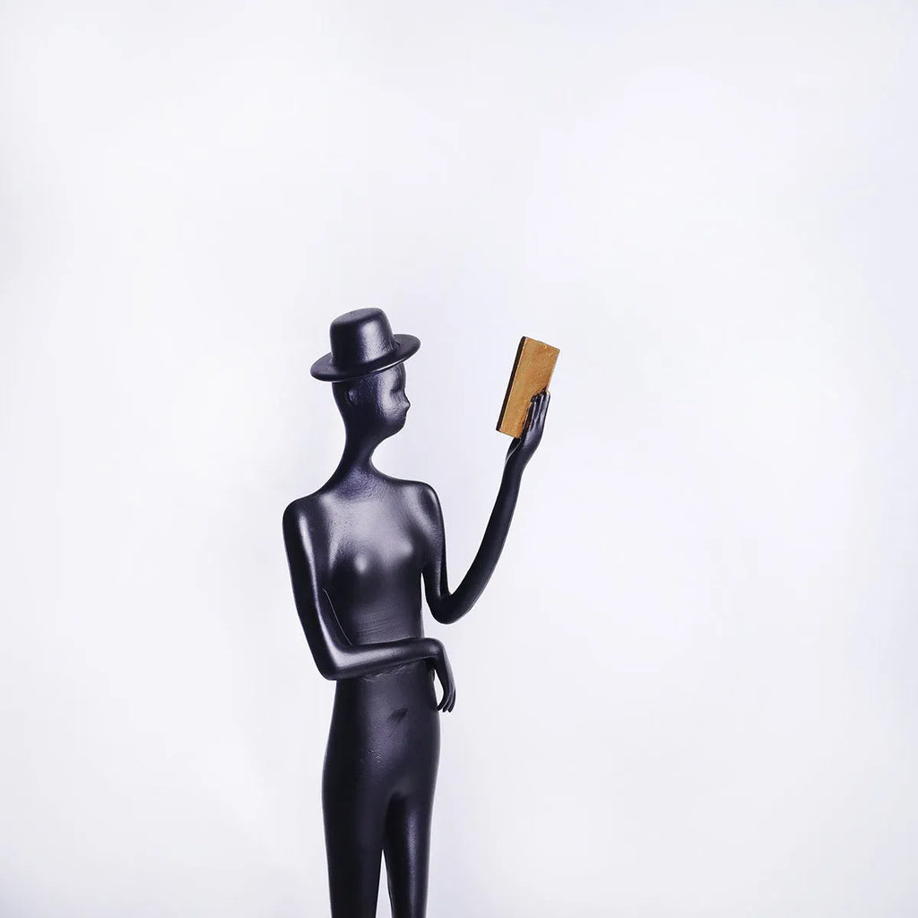 Black cast aluminium reading woman desktop sculpture measuring 51 cm tall