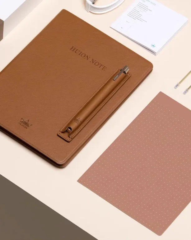 Huion Note X10 Elk Brown digital drawing tablet with PW320 pen on a desk