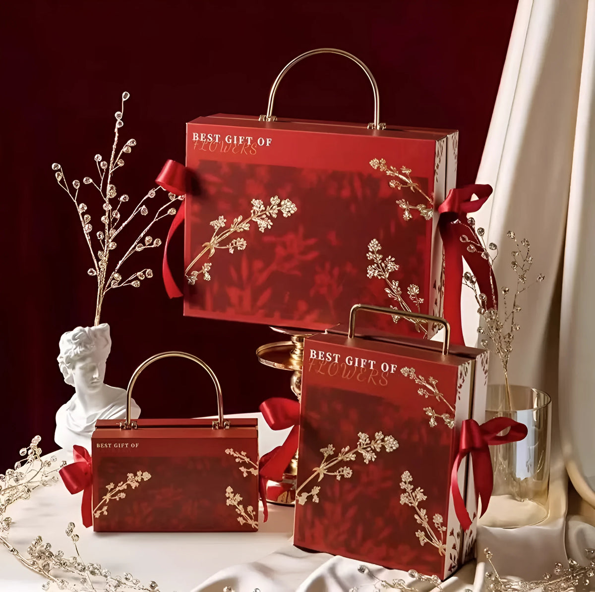 Hand gift box in paper and cardboard, champagne gold, glacier blue or red, with string lights, raffia or single box options.