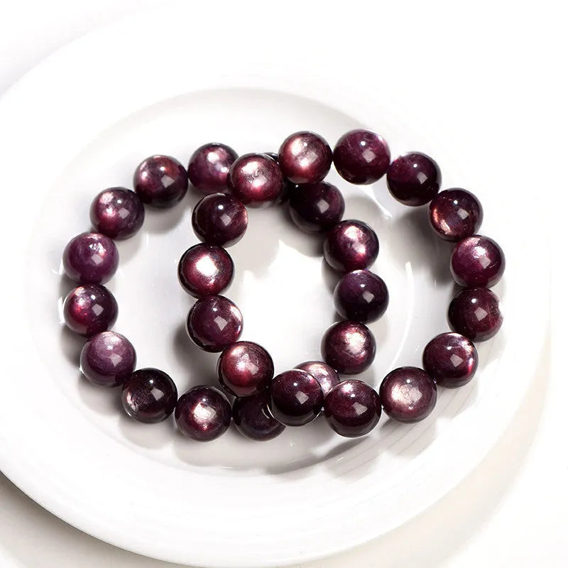 Natural purple lepidolite crystal round bead bracelet on a white background.