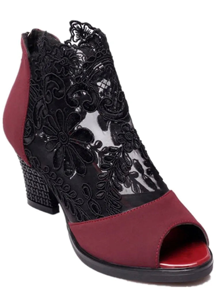 Black lace gladiator sandals with a square high heel, zip closure, and peep toe on a woman's foot
