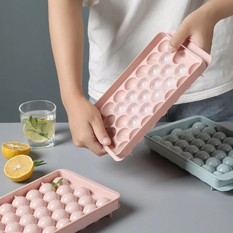 Sky blue and pink plastic round ice ball mould trays with 18 and 33 grids.
