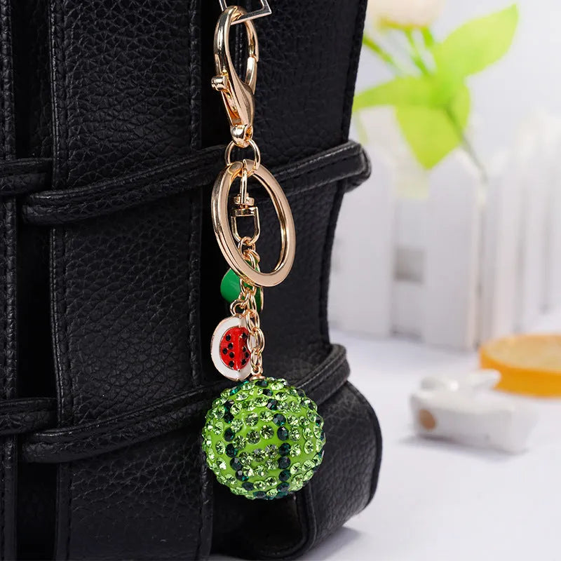 Green zinc alloy watermelon-shaped keychain measuring 12 cm.