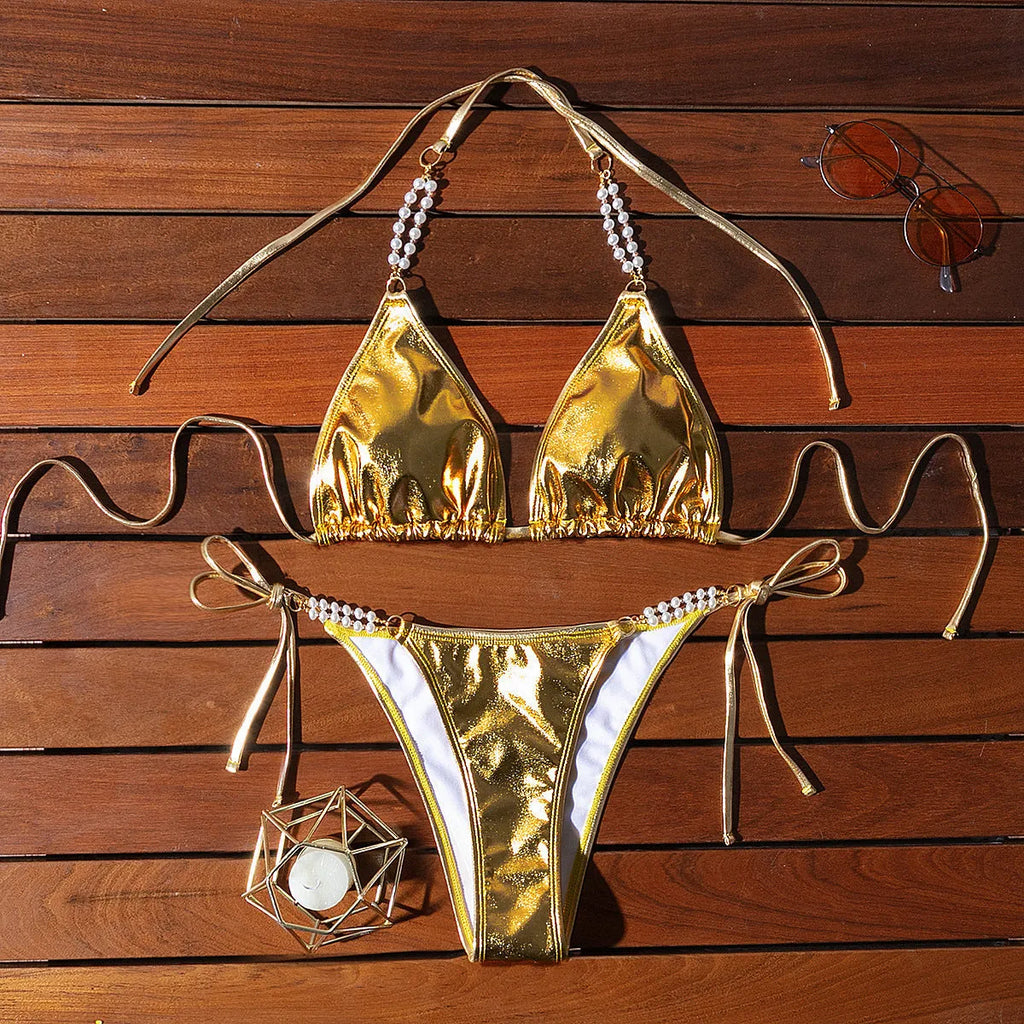 Gold halter neck bikini top with lace-up front and pearl chain, paired with brief-style bottoms
