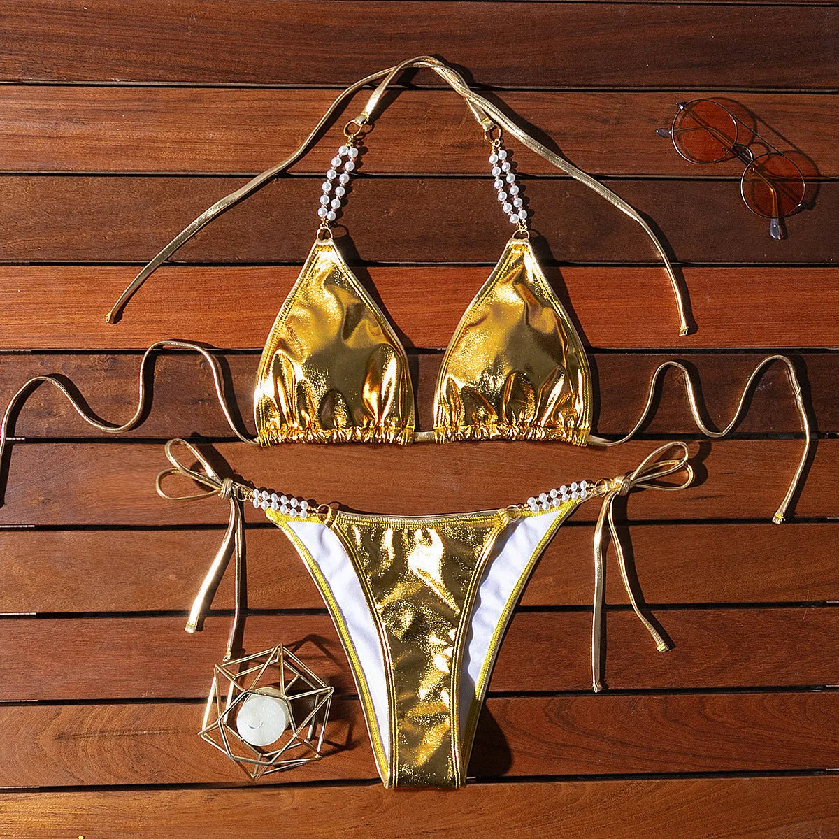 Gold halter neck bikini top with lace-up front and pearl chain, paired with brief-style bottoms